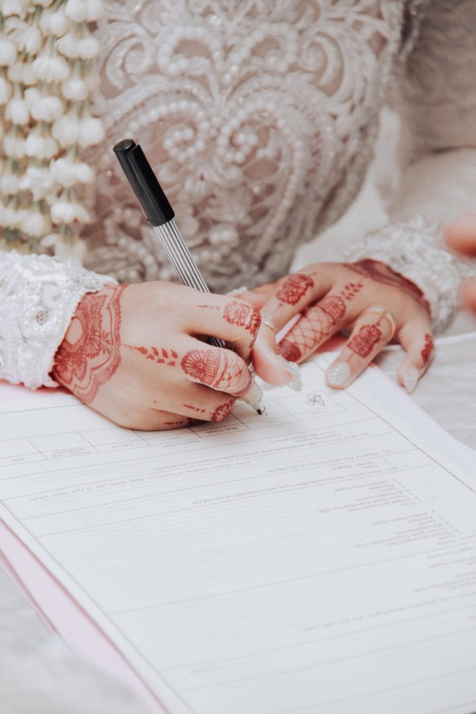 Indian woman signing her marriage license. 